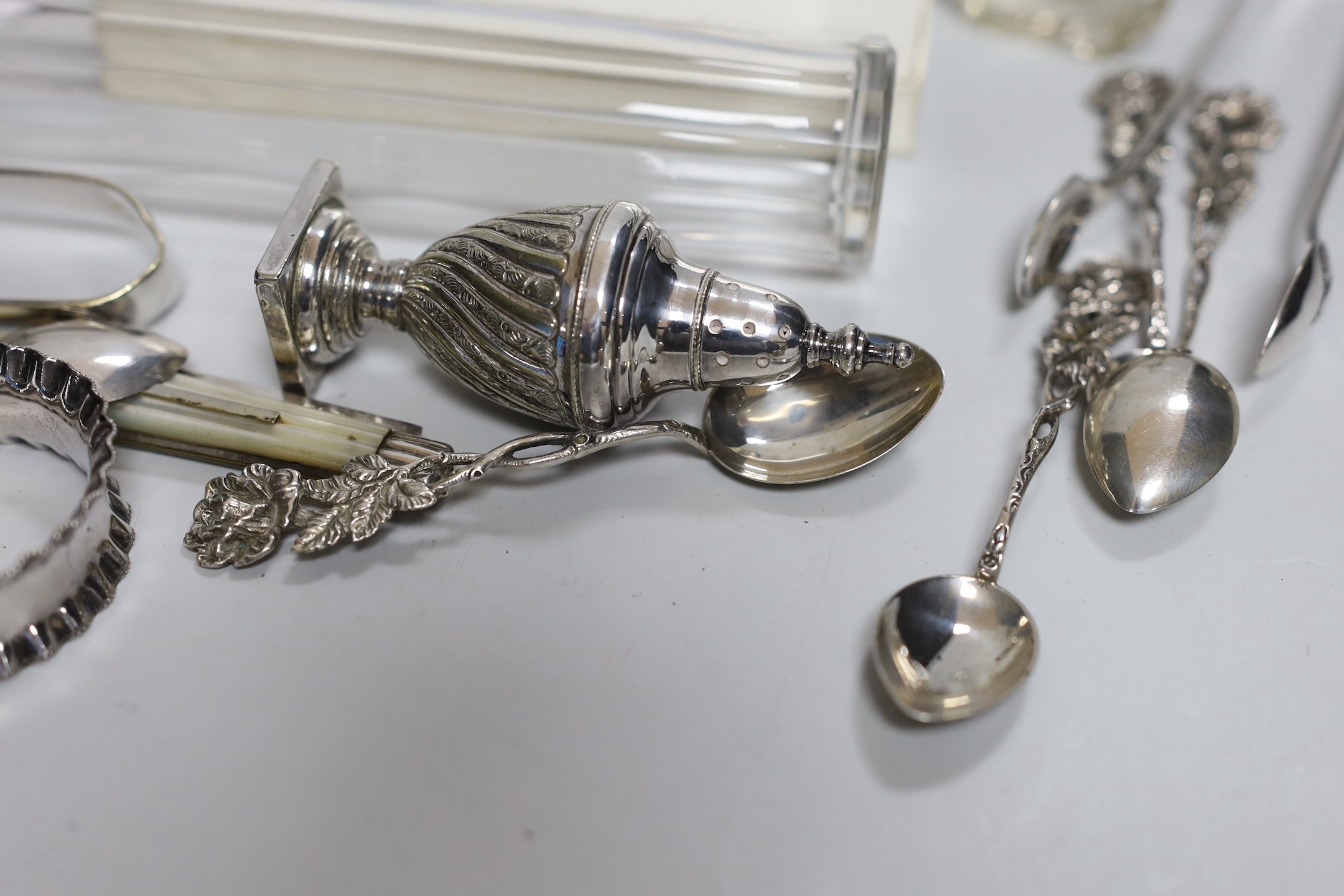 Assorted minor silver ware including a George V toast rack by James Dixon & Sons, 86mm, two napkin rings, a mounted glass toilet jar and condiment, pair of sugar tongs, a fruit knife, a commemorative spoon, a mounted sma